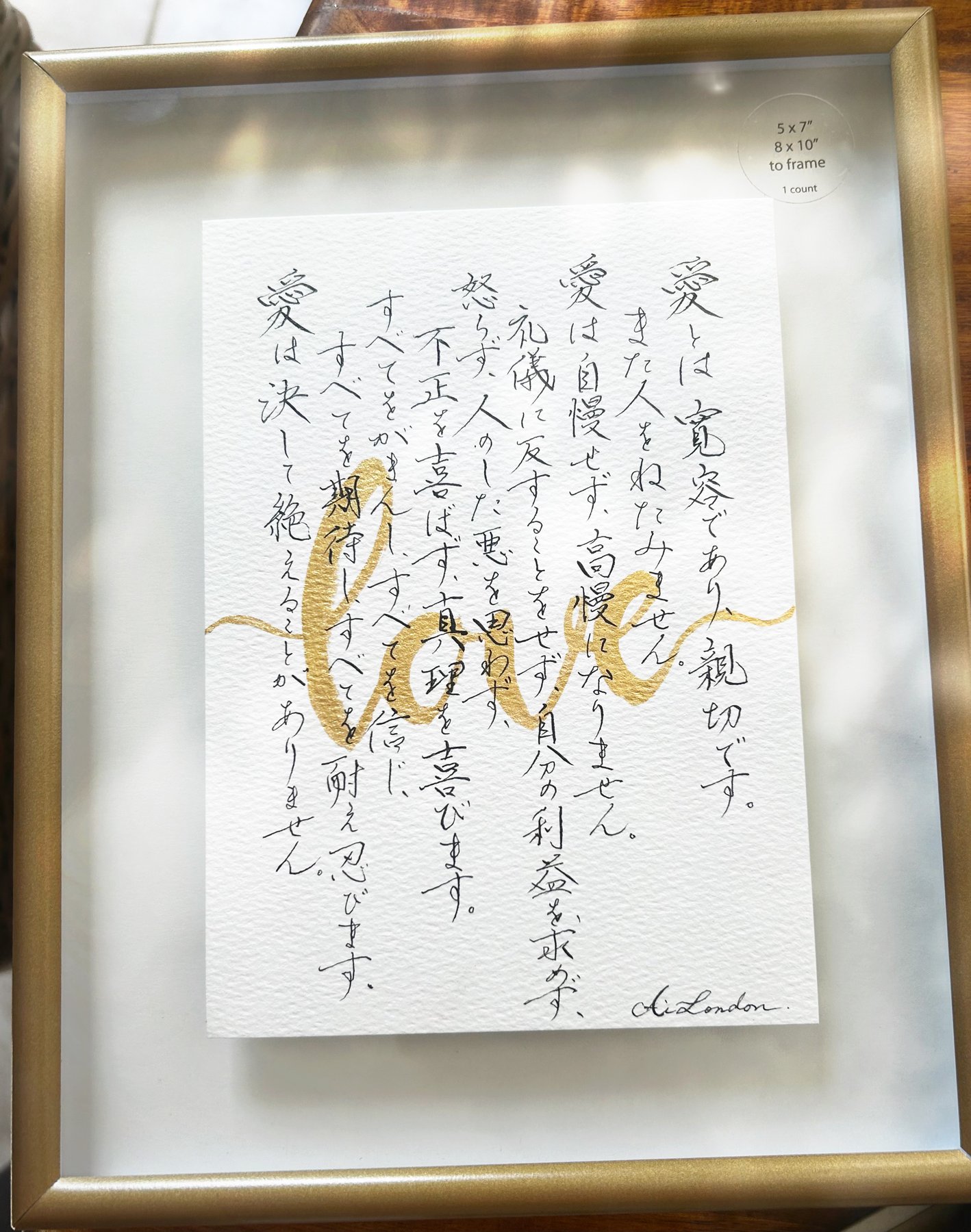 愛 — a passage written in Japanese with gold-leaf lettering, by Ai London